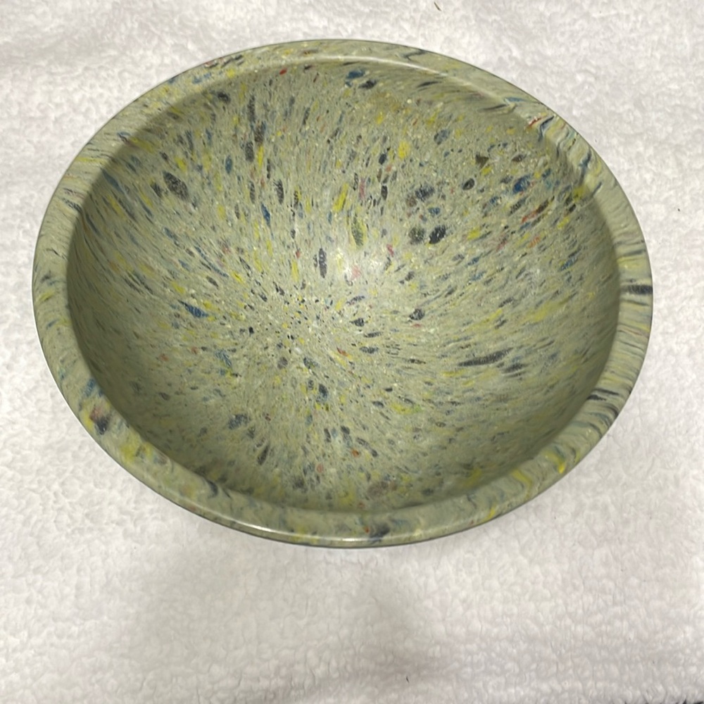 Melamine bowl.  Speckled green color with blue, yellow, black and red.